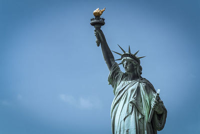 Low angle view of statue against blue sky