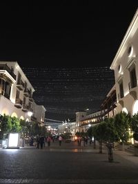 Illuminated city against sky at night