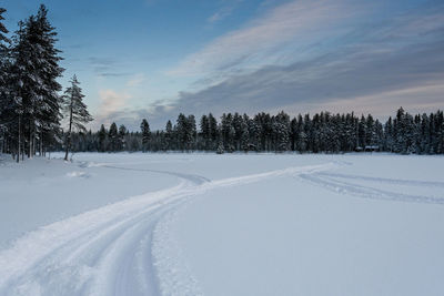 Snow covered field against sky