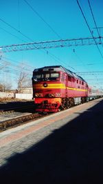 Train on railroad track against blue sky