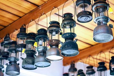 Low angle view of illuminated light bulbs hanging from ceiling