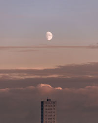 View of high rise apartment building against dusk sky.