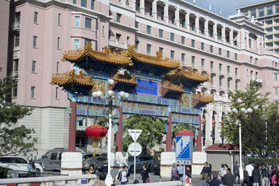 People on street by buildings in city