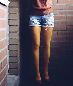 Midsection of woman standing against wall