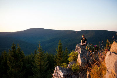 Man on rock against sky