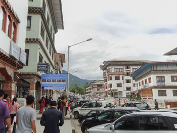 People on city street against sky