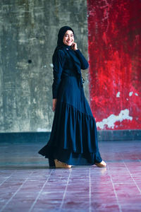 Portrait of woman standing against wall