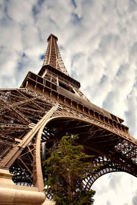 Low angle view of eiffel tower against cloudy sky