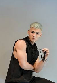 Portrait of young man standing against white background