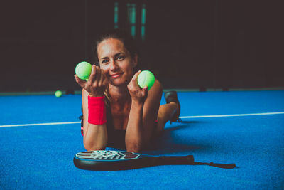 Portrait of beautiful woman playing padel tennis court indoor