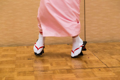 Low section of woman standing on hardwood floor