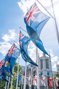 Low angle view of flags against blue sky