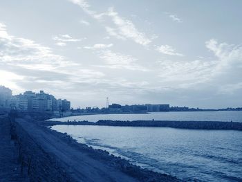 Scenic view of river by buildings against sky
