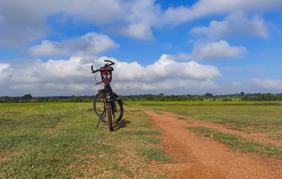 Bicycle on field against sky