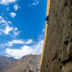 Low angle view of man on cliff against sky