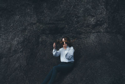 Woman sitting on tree trunk