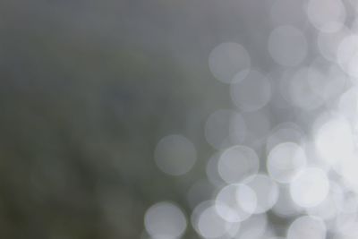 Defocused image of illuminated lights against sky