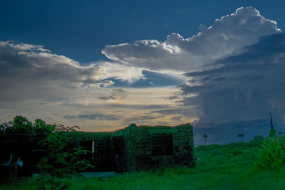 Panoramic shot of abandoned building on field against sky