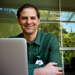 Portrait of smiling man sitting against glass building