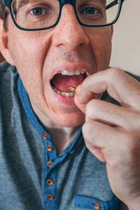 Close-up portrait of man eating insect