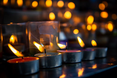 Close-up of candles burning in illuminated building