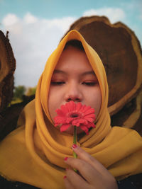 Close-up of woman holding yellow flower