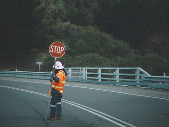 View of man standing on road sign