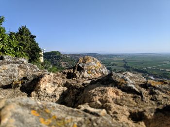 Scenic view of rocks and sea against clear blue sky