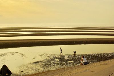 People on beach against sky