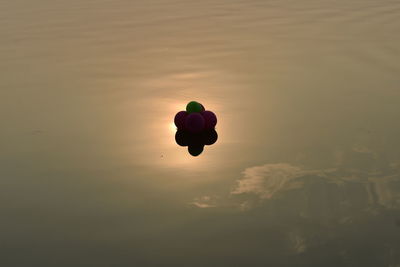 Silhouette of balloons against sky during sunset