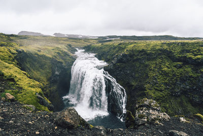 Waterfall in the beautiful landscape in icelandic environment during cloudy, misty day