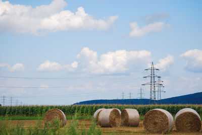 Hay bales on field against sky