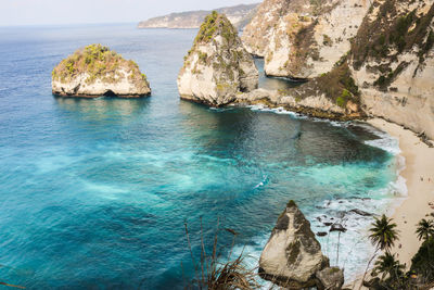 Rocks in sea against blue sky