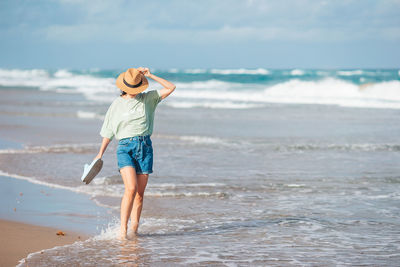 Full length of woman standing at beach