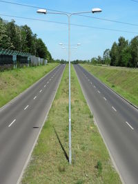Road amidst field against sky