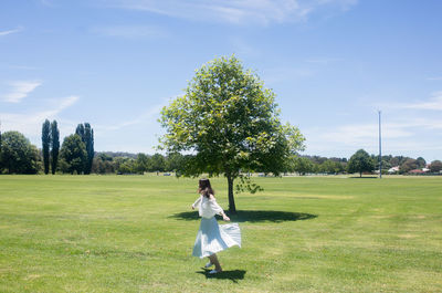 Full length of woman standing on field against sky