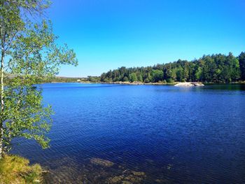 Scenic view of lake against clear blue sky