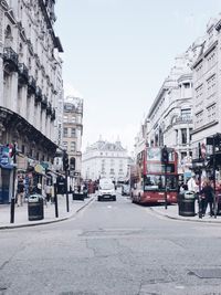 Cars on city street against clear sky