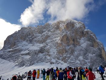 Low angle view of people standing on snow covered mountain