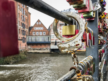 Close-up of padlocks on canal by building