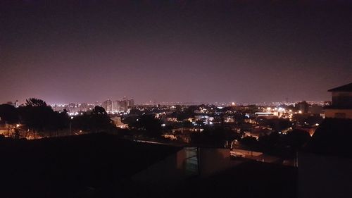 High angle view of illuminated buildings against sky at night