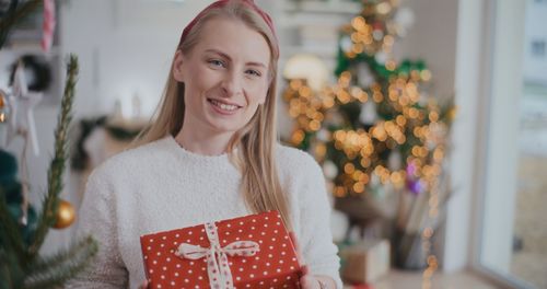 Portrait of young woman holding gift