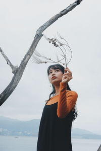 Young woman looking at sea against sky