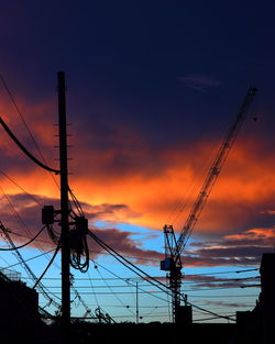 Silhouette of electricity pylon against sky during sunset