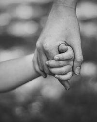 Cropped image of mother holding child hand