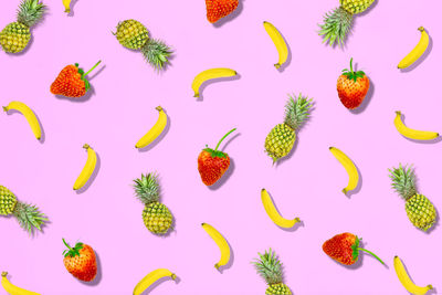 High angle view of fruits on pink background