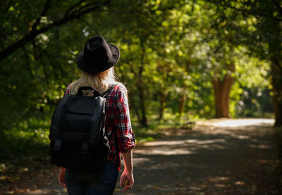 Rear view of woman standing in forest
