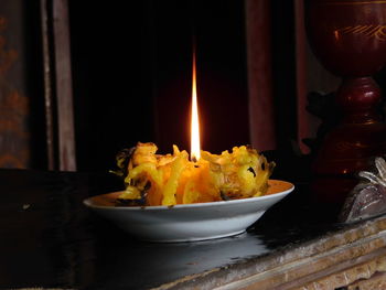 Close-up of illuminated candles on table