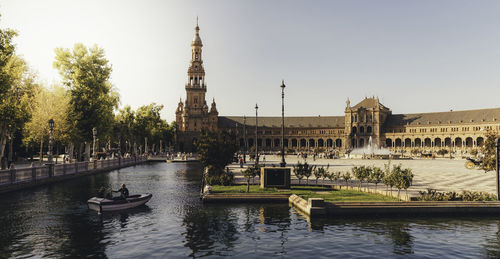 Boats in river with buildings in background