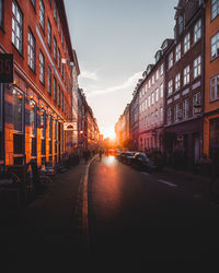 View of city street and buildings at sunset